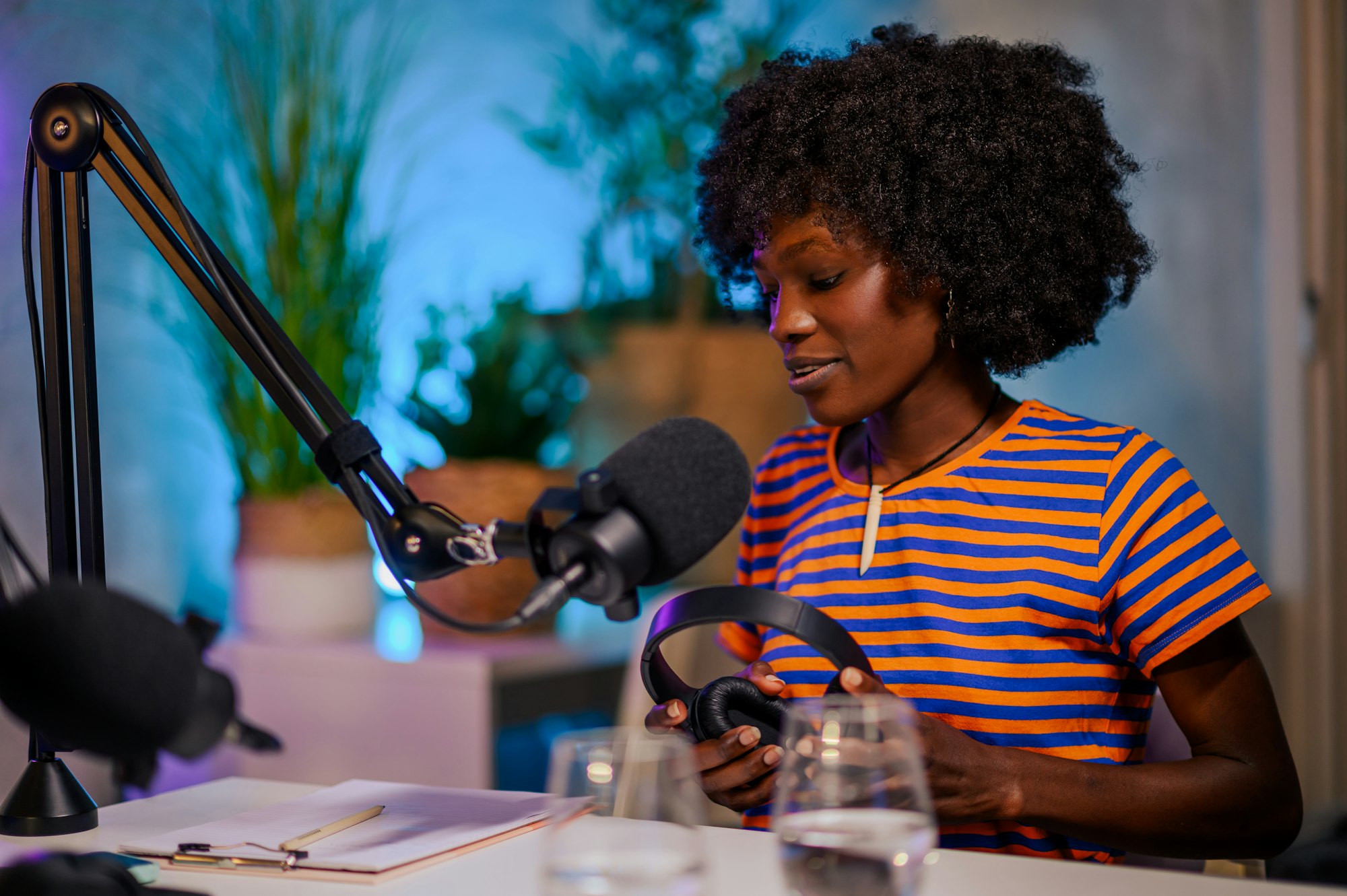 Portrait of a multicultural journalist sitting in a podcast studio